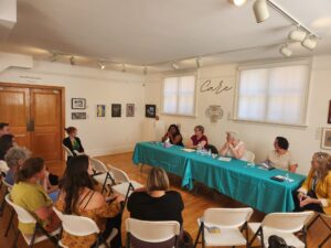 An audience engages with a panel of speakers in an art gallery