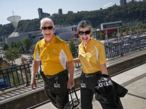 Couple in matching yellow shirts and sunglasses walking along path