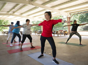 woman participates in outdoor yoga class