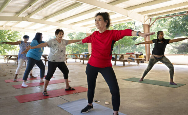woman participates in outdoor yoga class