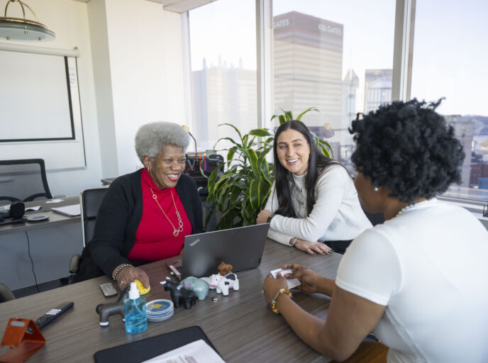 Intergenerational coworkers enjoy a conversation in an office