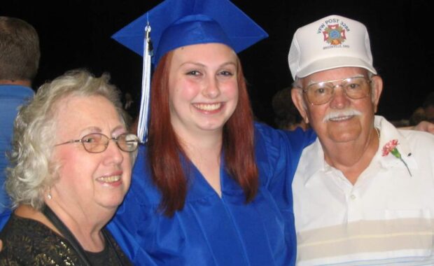 Smiling with Grandma and Grandpa at Alexandra's high school graduation in 2012.