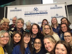 Group of Area Agency on Aging staff take a photo in the photo booth at the Senior Expo