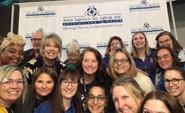 Group of Area Agency on Aging staff take a photo in the photo booth at the Senior Expo