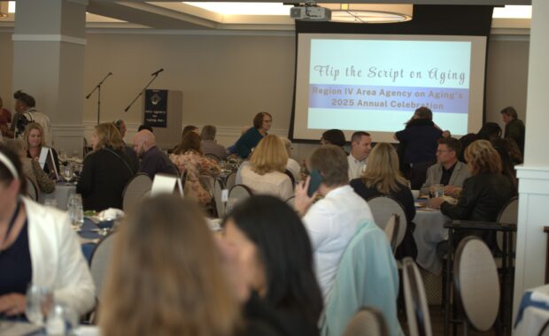 annual celebration with people seated at tables. Screen says Flip the Script on Aging