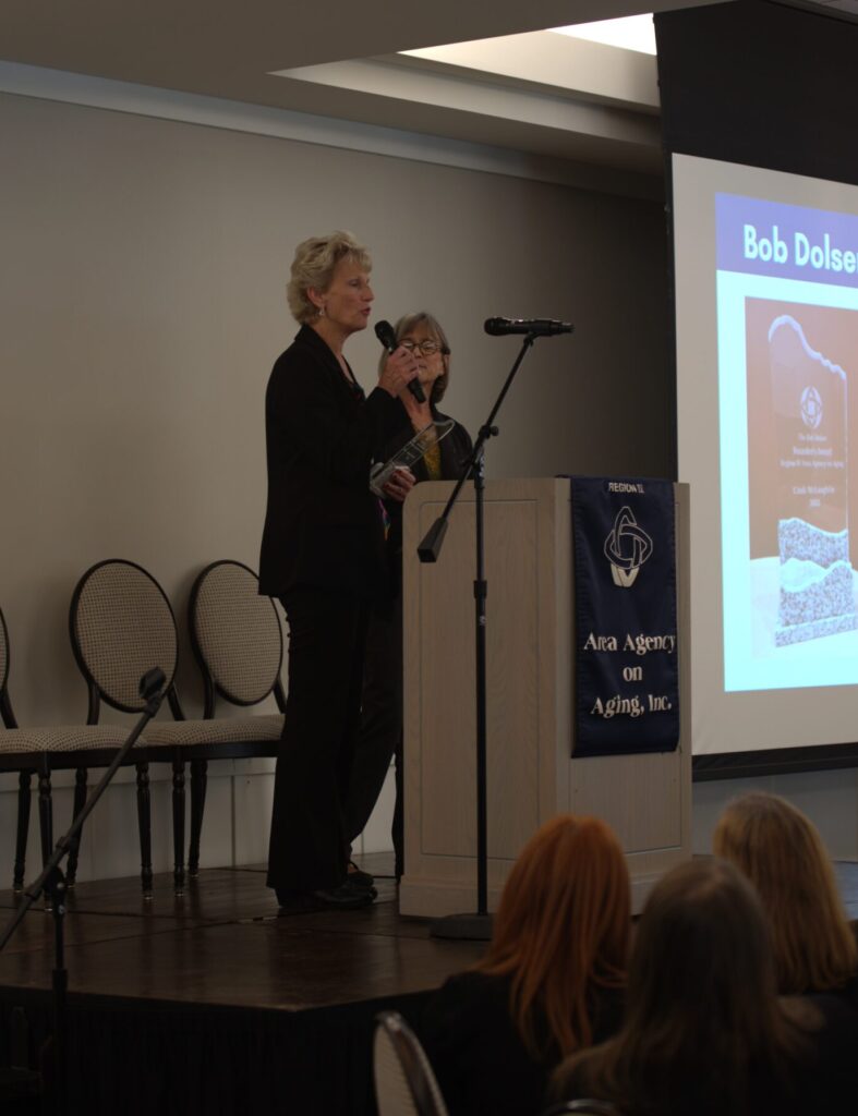 Woman accepts award at podium