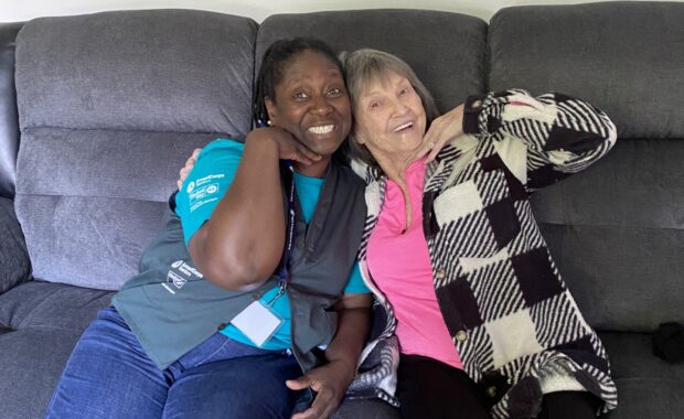 Senior Companion Marie poses with client on a couch