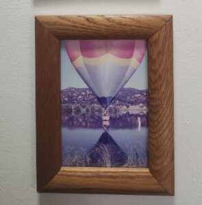 A hot air balloon floats over a body of water