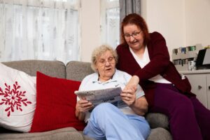 women sitting on couch reading newspaper