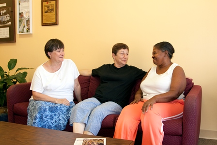 group of three women sitting on couch