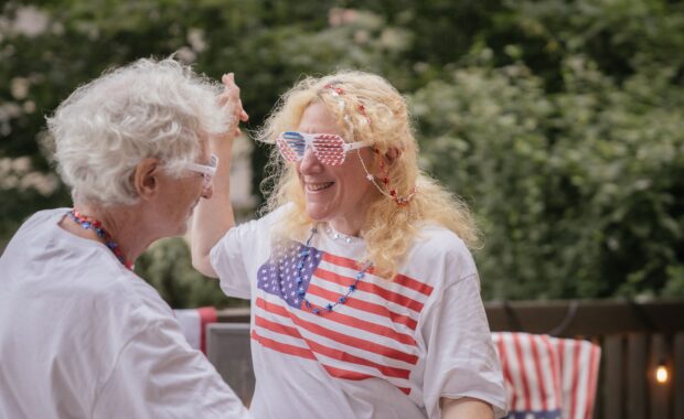 Couple wearing American flag shirts and glasses dancing