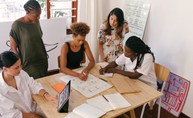 a group of employees sit around a table