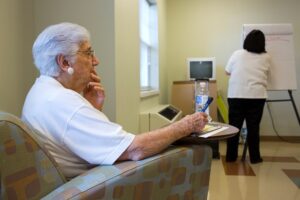 Woman sitting while thinking, holding a pen to a piece of paper