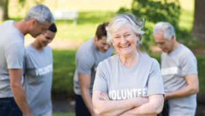 woman wearing shirt with "volunteer" on it stands with arms crossed