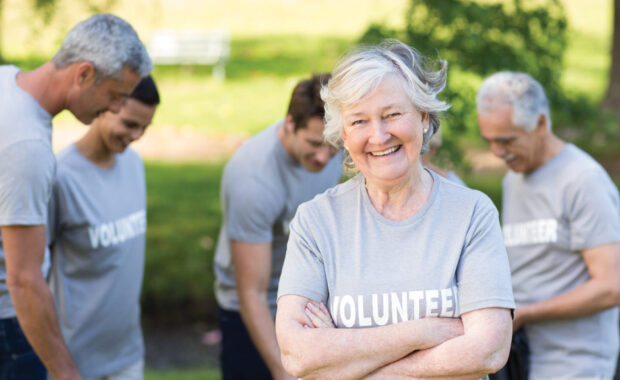 woman wearing shirt with "volunteer" on it stands with arms crossed