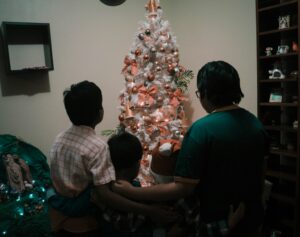 backs of family looking at Christmas tree