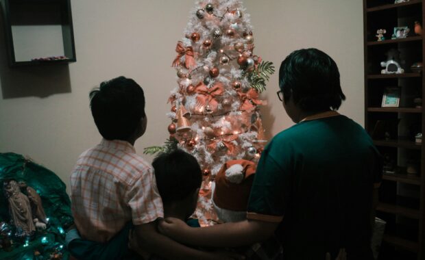 backs of family looking at Christmas tree